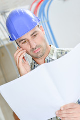 Man on phone looking at plans