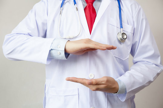 Medical Doctor With Two Hands In Position To Protect Something (focus On Hand, Blur Out The Gown). It Indicates Many Aspects Such As Coverage, Support, Assurance, Reliability