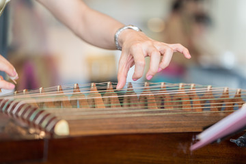 Hand of woman playing guzheng. - 113940257