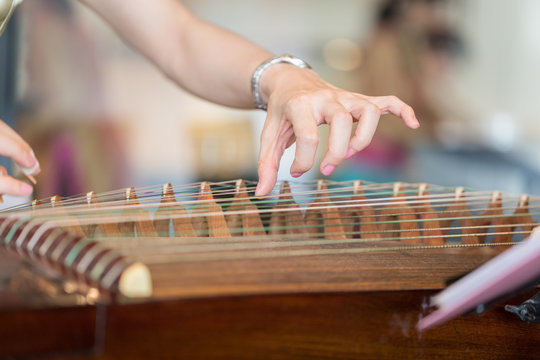 Hand of woman playing guzheng.