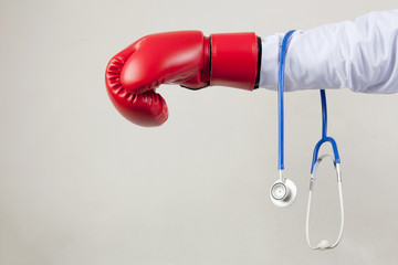 Doctor wearing boxing gloves in white background