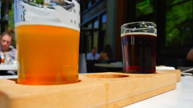 4K Hand on Glass, Craft Beer Tasting Samples on Outside Table at Pub