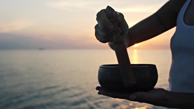 Relaxing video: woman playing singing bowl at the beach
