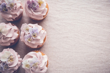Purple cupcakes with sugared edible flowers copy space  toning background