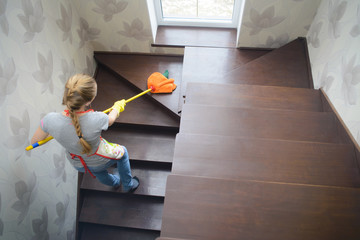 young beautiful woman cleaning wooden stairs by mop