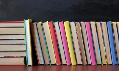 Books on the shelf in the background of a school blackboard.