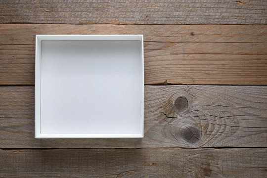 Empty white open box on wooden background