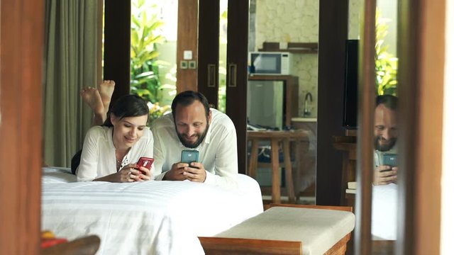 Young couple using smartphone in the bedroom
