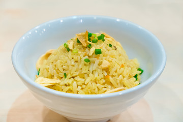 Thai garlic fried rice with vegetable on top in white bowl, on w