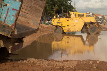 WS view of waterlogged muddy roadside constructon vehicles with