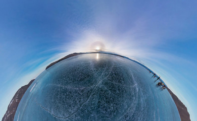 Tourists make the transition ice on Lake Baikal ice at sunset. 
