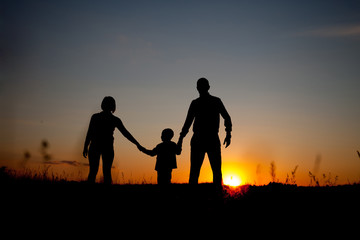 Fototapeta na wymiar silhouette of family on the outdoor at dusk. Concept of friendly family.
