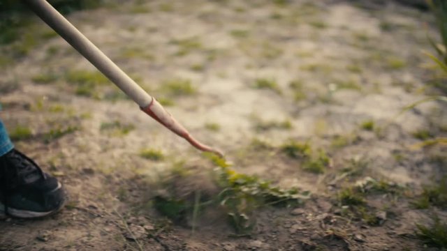 Farmer Using Hoe On Dirt At Farm
