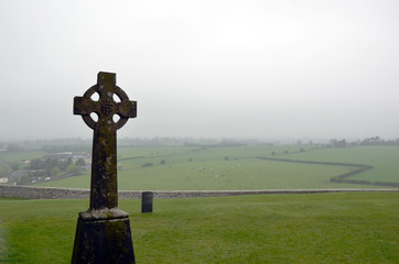 celtic cross on old cemetery and mist background