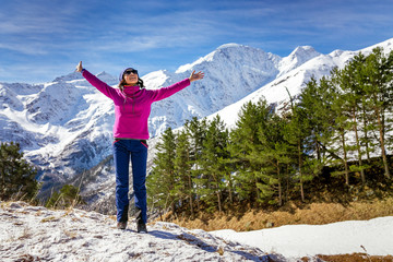 Young woman admires the snow capped mountains in Georgia