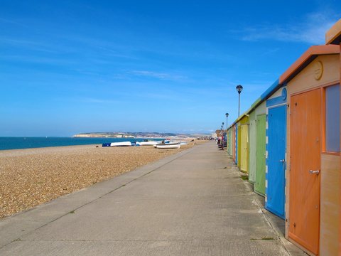 colorful beach huts on pebble beach in Seaford, East Sussex, England