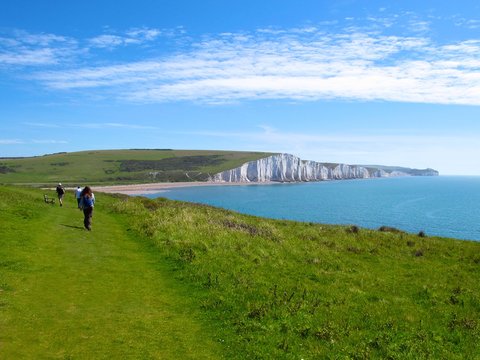 Hikers approach white cliffs of the Seven Sisters in Eastbourne, East Sussex, England