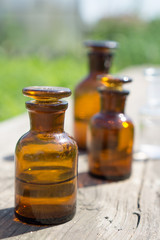 little brown bottles on wooden board and green grass