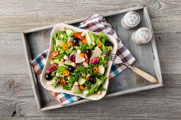 Italian salad with fresh vegetables with black olives and Parmes