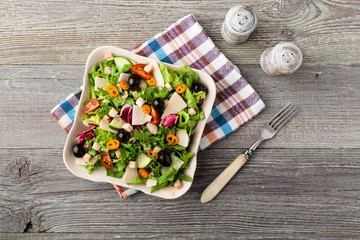 Italian salad with fresh vegetables with black olives and Parmes