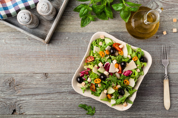 Italian salad with fresh vegetables with black olives and Parmes