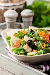 Italian salad with fresh vegetables with black olives and Parmes