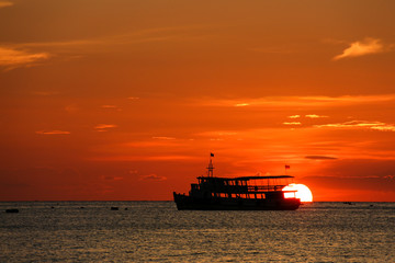 Obraz premium Sunset on the beach with fishing boat