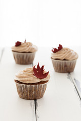 cupcake med höstlöv mot vit trä bakgrund