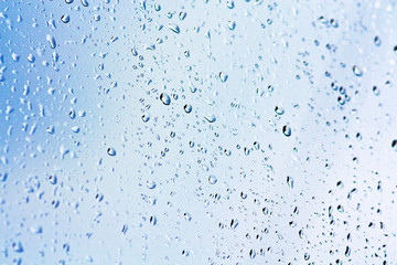 Stream of water in heavy rain. Raindrops on window pane. Blur effect. 