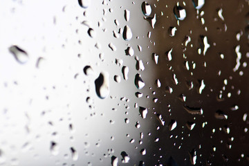 Stream of water in heavy rain. Raindrops on window pane. Blur effect. 