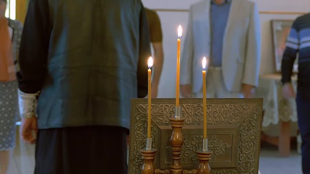 priest in the Russian Orthodox Church is back lit prayer candles slow motion video