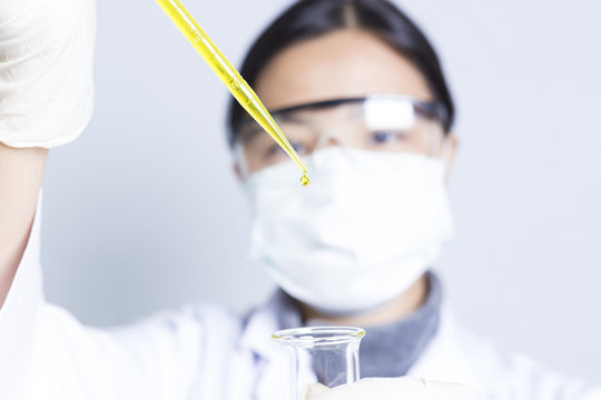 Woman Sciencetist: Researcher Holding at a Liquid Solution on Is