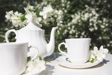 Tea service in the garden. Cups of tea and tea pot. Drinking tea