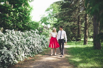 Stylish beautiful happy wedding couple kissing and embracing in Botanical Garden