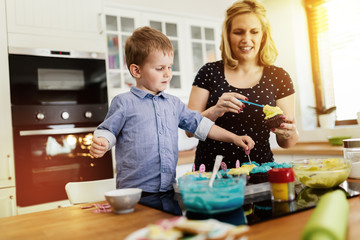 Child helping mother make cookies