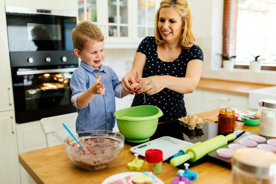 Child helping mother bake cookies