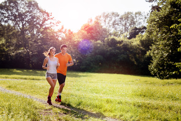 Beautiful couple jogging in nature - obrazy, fototapety, plakaty