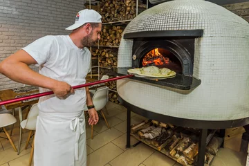 Crédence de cuisine en verre imprimé Pizzeria Young kitchen chef check pizza in oven