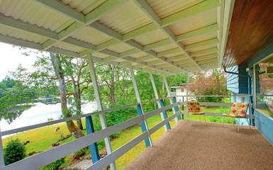 Backyard covered deck with carpet floor and water view.