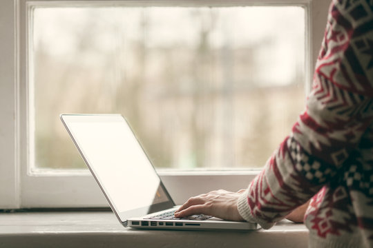 Woman with laptop on the window sill.