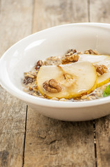 Oatmeal with pear and walnuts in the bowl