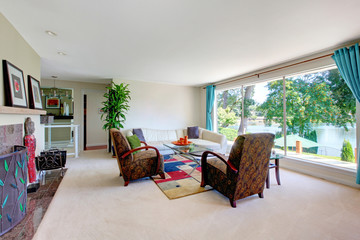 Fototapeta premium Light tones living room with leather couch, fireplace and water view.
