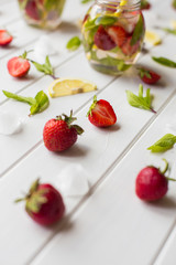 Strawberry lemonade with lemone and ice on a wooden table
