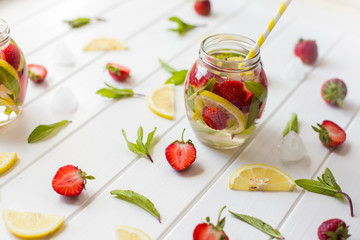 Summer cold drink with strawberry, mint and ice on a light background