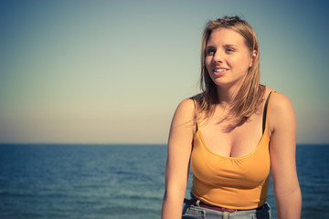 Lovely blonde girl relaxing outdoor by seaside