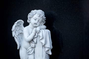Trauriger Engel in weiß auf Hintergrund schwarz.