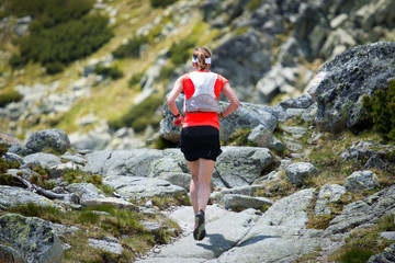 young woman training running on the trail in high mountain alpine nature