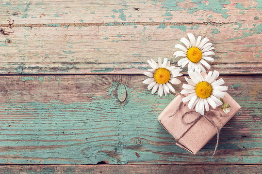 Background daisies and Gift box on old boards with shabby paint.