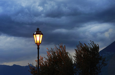 Street lamp shining at evening against stormy clouds, Varenna, Italy, sept. 2015