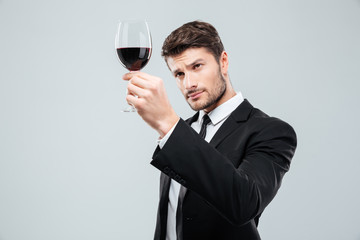 Man sommelier tasting and looking at red wine in glass